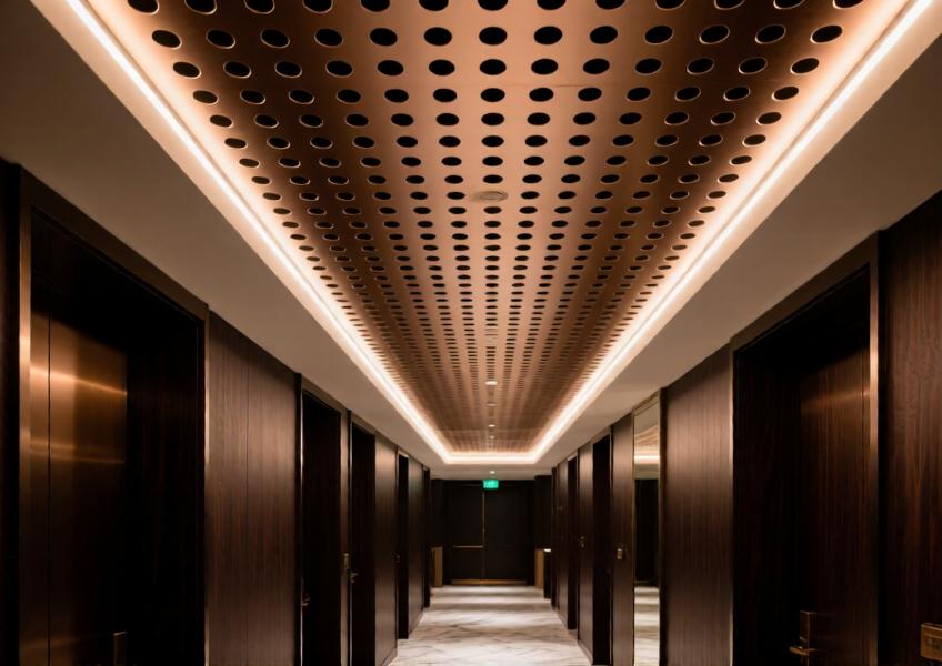 Close-up of a perforated aluminum ceiling panel in a luxury hospitality setting, emphasizing texture, lighting integration, and premium materials.