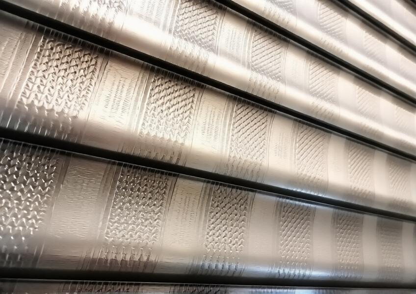 Close-up view of aluminium facade panels with textured surface and metallic finish, highlighting craftsmanship.